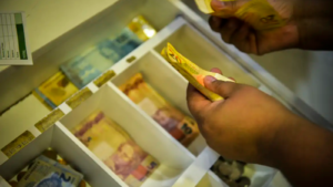 Dinheiro em caixa registradora, imagem sobre INPC e inflação em agosto de 2026. Imagem: Marcello Casal Jr./Agência Brasil
